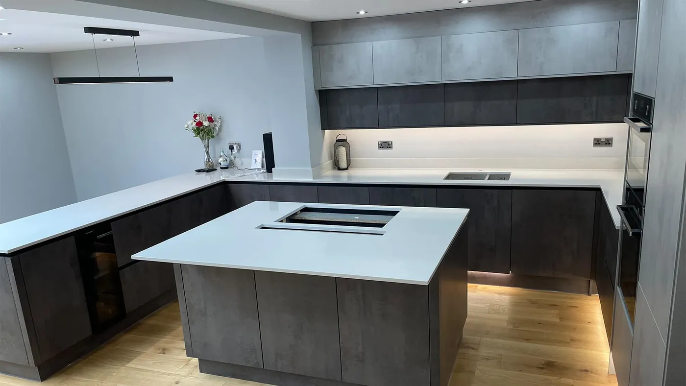 Dark concrete-effect U-shaped kitchen with a central island and downdraft extractor