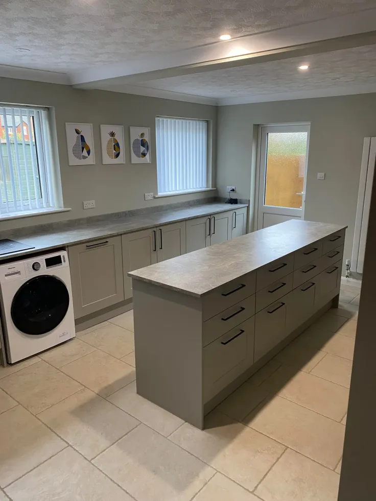 Sage shaker kitchen with a long drawer island, integrated appliances and tiled floor