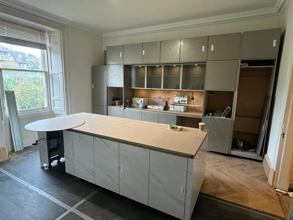 Kitchen installation mid-fit — carcasses and island in place before worktops and flooring