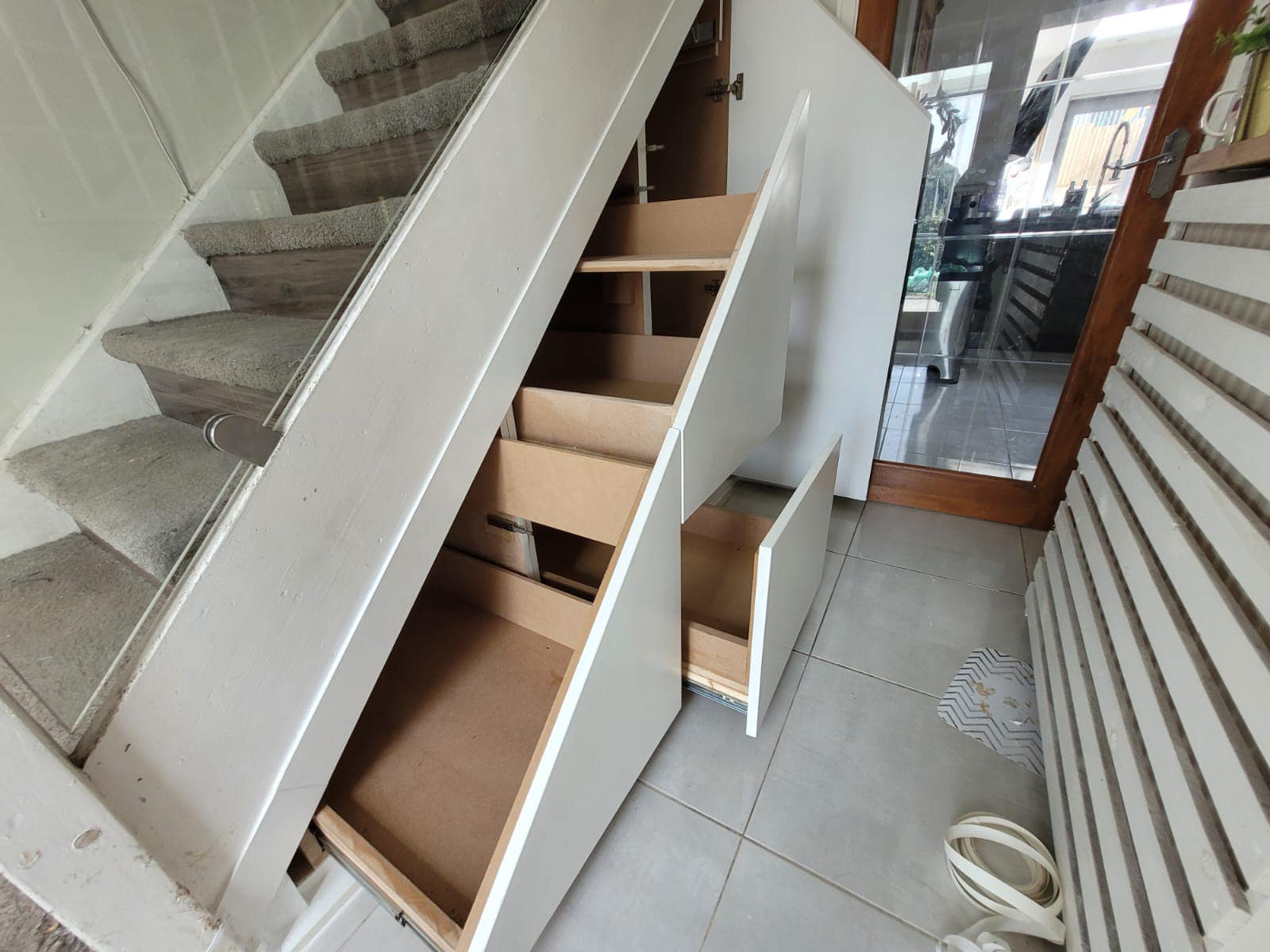Modern under stairs storage cabinet installation featuring seamless handleless doors